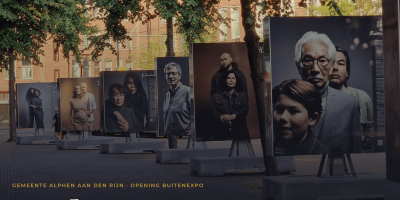 Een lijn van portretten van verschillende mensen in een openbare ruimte